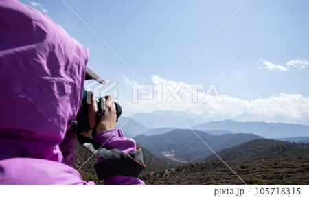 Woman photographer taking photo for high altitude mountains, China Woman photographer taking photo for high altitude mountains, China 105718315