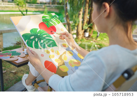 Creative art concept, Female artist sitting in park and painting picture on canvas with happiness Creative art concept, Female artist sitting in park and painting picture on canvas with happiness 105718953