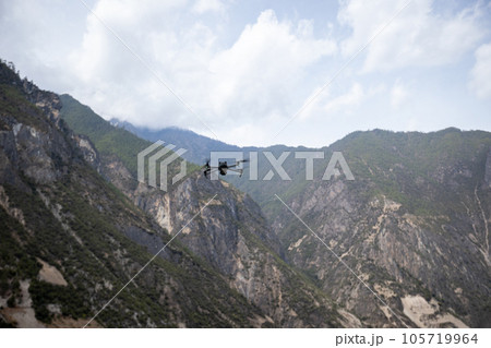 Flying drone in high altitude mountains Flying drone in high altitude mountains 105719964