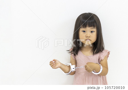 玩具の手錠をはめた女の子(日本人、3歳) 玩具の手錠をはめた女の子(日本人、3歳) 105720010