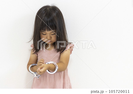 玩具の手錠をはめた女の子(日本人、3歳) 玩具の手錠をはめた女の子(日本人、3歳) 105720011