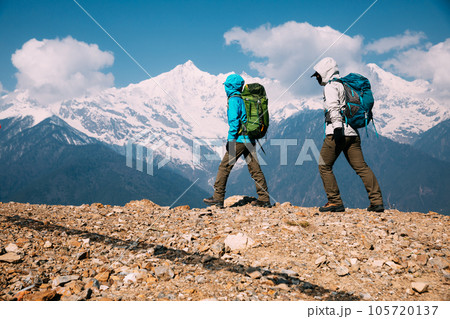 Two women backpackers hiking in beautiful winter high altitude mountains Two women backpackers hiking in beautiful winter high altitude mountains 105720137