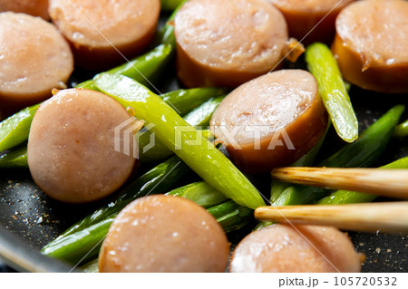 フランクフルトソーセージとにんにくの芽を炒める調理シーン。 フランクフルトソーセージとにんにくの芽を炒める調理シーン。 105720532