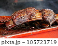 Cooking BBQ pork ribs and chicken on wire wrack in fire. 105723719