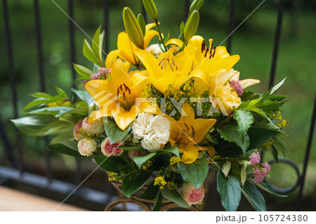 a bouquet of beautiful yellow flowers in a vase outdoors a bouquet of beautiful yellow flowers in a vase outdoors 105724380