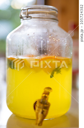 a large jar with fresh homemade lemonade and orange slices. a large jar with fresh homemade lemonade and orange slices. 105724382