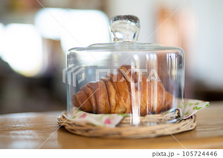 delicious fresh croissant on a plate under a glass cover 105724446