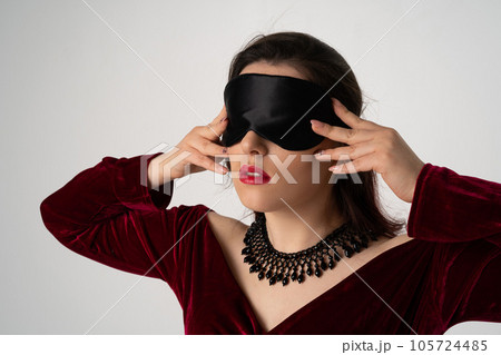 elegant luxury blind woman in evening dress with blindfold posing on white background elegant luxury blind woman in evening dress with blindfold posing on white background 105724485