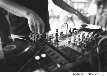 a DJ plays music on a controller at a party 105724805