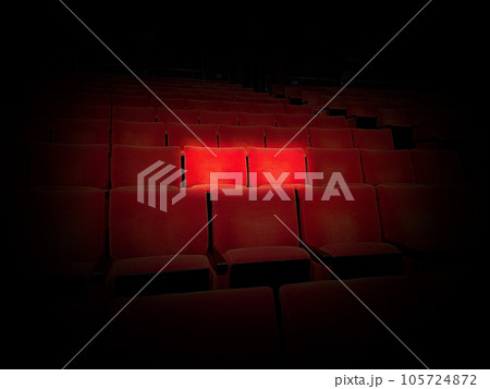 映画館のスポットライトで浮かぶ赤の座席 映画館のスポットライトで浮かぶ赤の座席 105724872
