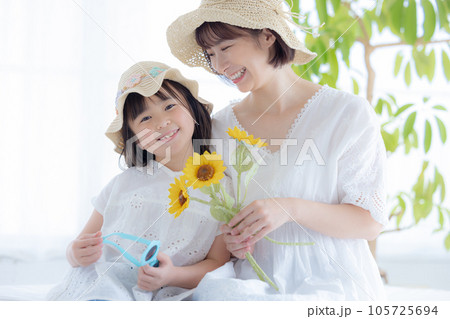 ひまわりを持っている親子のポートレート 105725694