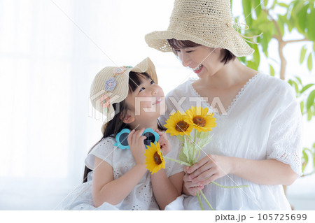 ひまわりを持っている親子のポートレート 105725699
