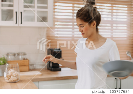 Woman rearrange equipments items and cleaning the kitchen. Woman rearrange equipments items and cleaning the kitchen. 105727684