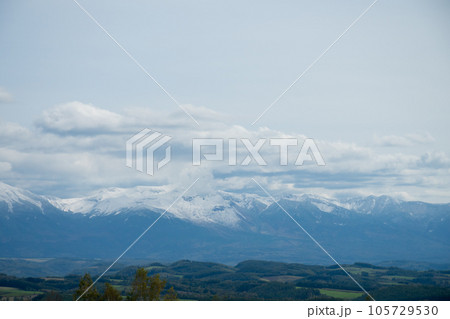 冠雪の山並みと秋の丘陵地帯　十勝岳連峰 105729530