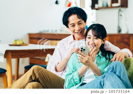 スマホを見る若い夫婦 105733104