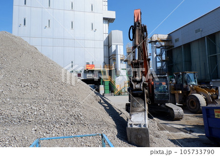 リサイクル施設で活躍する油圧ショベル 105733790