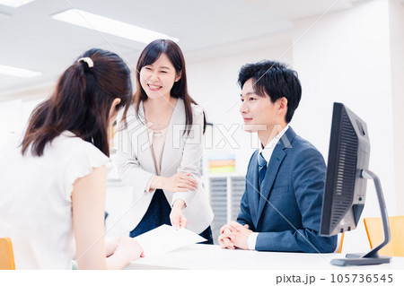 窓口でにこやかに対応をするスタッフ 窓口でにこやかに対応をするスタッフ 105736545