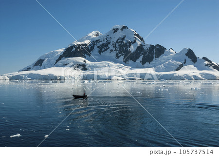 Tourists observing a glacier on the Antarctica, Paradise bay, Antartic Peninsula. Tourists observing a glacier on the Antarctica, Paradise bay, Antartic Peninsula. 105737514