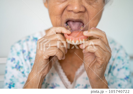 Asian elderly woman patient holding to use denture, healthy strong medical concept. 105740722