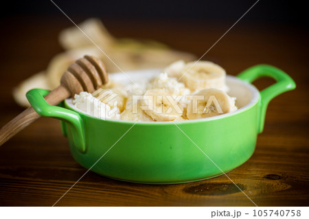 homemade cottage cheese in a bowl with bananas and honey homemade cottage cheese in a bowl with bananas and honey 105740758