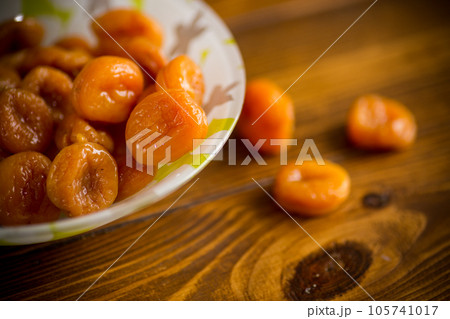 delicious dried apricots in a bowl on a wooden table 105741017