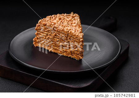 Delicious sweet puff waffle cake with cream and nuts cut into pieces Delicious sweet puff waffle cake with cream and nuts cut into pieces 105742981