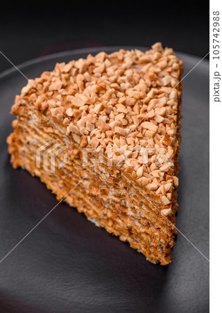 Delicious sweet puff waffle cake with cream and nuts cut into pieces 105742988