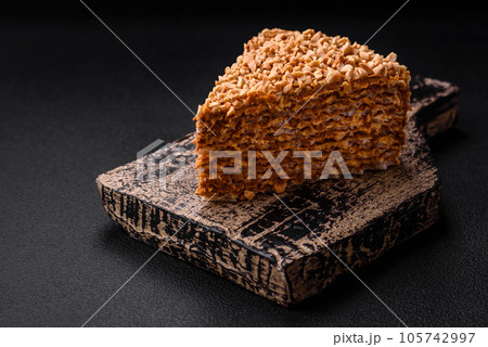 Delicious sweet puff waffle cake with cream and nuts cut into pieces 105742997