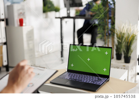 Executive manager planning company budget and using laptop with chroma key screen. Entrepreneur analyzing sales metrics and working on portable computer with green display 105745538