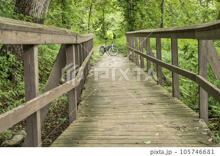 folding bike and footbridge - Katy Trail (side nature trail) near Rocheport, Missouri, in summer scenery folding bike and footbridge - Katy Trail (side nature trail) near Rocheport, Missouri, in summer scenery 105746681