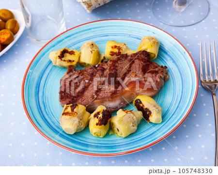 Grilled veal steak with artichokes, healthy dinner Grilled veal steak with artichokes, healthy dinner 105748330