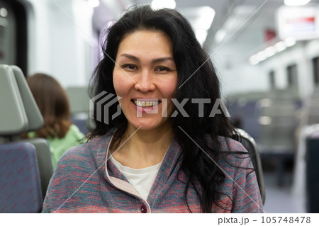 Woman with backpack sitting on bench in metropolitan train 105748478