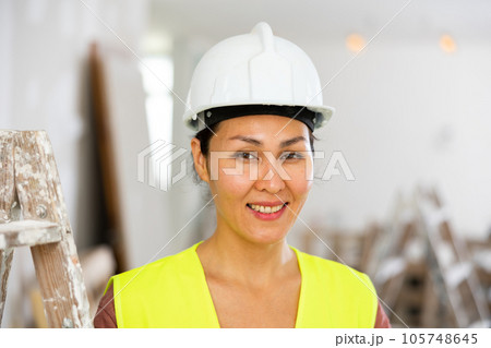 Portrait of positive woman builder during repair works 105748645