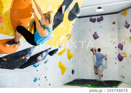 Bouldering, people and healthy lifestyle concept — young woman exercising at climbing gym 105748678