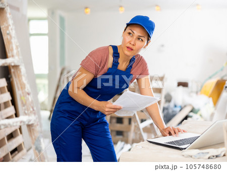 Female engineer using laptop during repair works 105748680
