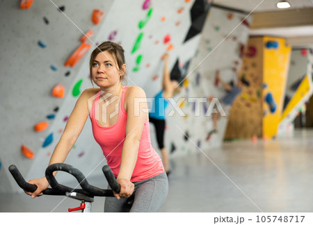 Sports girl on an exercise bike in climbing hall 105748717