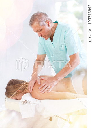 male masseur giving massage to female patient 105748945