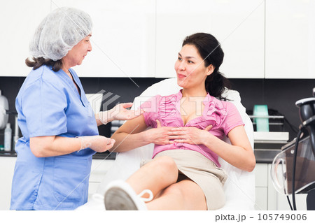 Plastic surgeon and woman discussing procedure of breast augmentation during consultation Plastic surgeon and woman discussing procedure of breast augmentation during consultation 105749006
