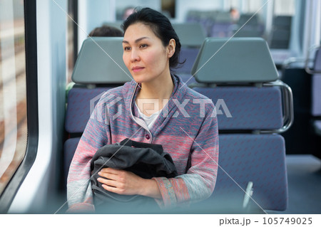 Portrait of a woman traveler with a backpack and a phone in train car Portrait of a woman traveler with a backpack and a phone in train car 105749025