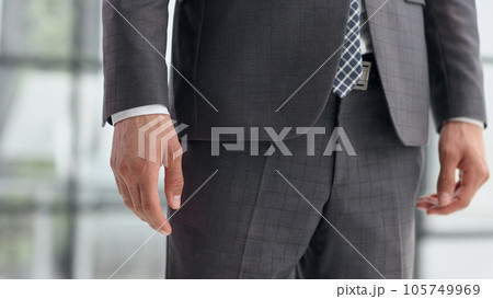 Handsome elegant young fashionista in classic suit, focus on body part arm and belt 105749969
