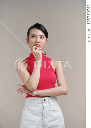 Pensive young woman posing Put hand prop up on chin, looking aside Pensive young woman posing Put hand prop up on chin, looking aside 105750742