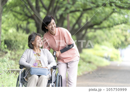 公園で会話する介護士と車椅子のシニア女性 105750999