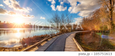 Wooden pathway in a city park by the lake. Sunset. Deer Lake, Burnaby, Vancouver, BC, Canada Wooden pathway in a city park by the lake. Sunset. Deer Lake, Burnaby, Vancouver, BC, Canada 105751613