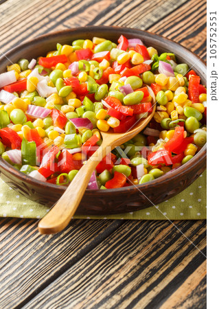 Summer vegetable salad with edamame beans close-up in a bowl. Vertical 105752551