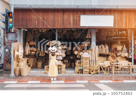 Young asian woman traveler in dress with hat traveling to wicker shop on Chang Moi Kao Road, Tourist visit at the old city in Chang Mai, Thailand. Asia Travel, Vacation and summer holiday concept Young asian woman traveler in dress with hat traveling to wicker shop on Chang Moi Kao Road, Tourist visit at the old city in Chang Mai, Thailand. Asia Travel, Vacation and summer holiday concept 105752802