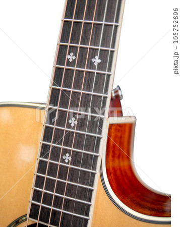 The neck of a six-string acoustic guitar on a dark background . guitar neck on a white background. Guitar fingerboard. selective focus. The neck of a six-string acoustic guitar on a dark background . guitar neck on a white background. Guitar fingerboard. selective focus. 105752896