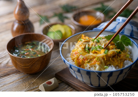 和食の定番！ふわふわの卵丼（たまご丼）お味噌汁と三つ葉を添えて 半熟卵（古板背景） 105753250