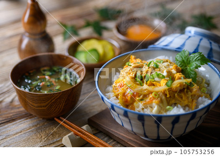 和食の定番！ふわふわの卵丼（たまご丼）お味噌汁と三つ葉を添えて 半熟卵（古板背景） 105753256