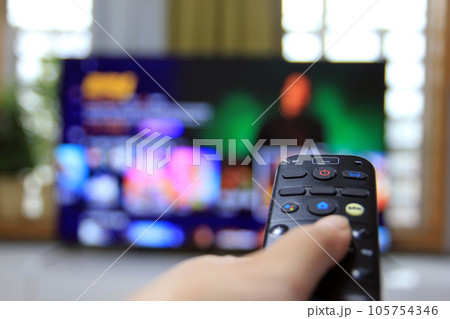 Cord Cutters Watching tv and using remote control 105754346