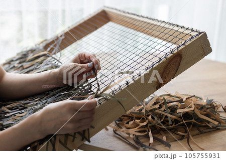 Woman weaving camouflage military mesh for helmet. Woman weaving camouflage military mesh for helmet. 105755931